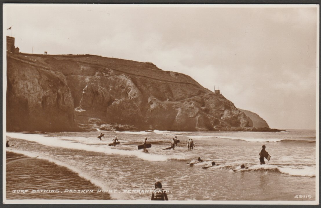 Sepia real photographic postcard showing a view of people surfing the waves at Droskyn Point in Perranporth, Cornwall.
Publisher not stated, No 29119, c.1930s.
Postally unused.
Very good condition, with minimal corner bumps.