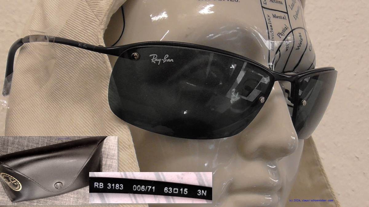 In der Abbildung ist die im Artikel bezeichnete Sonnenbrille auf einem Porzellankopf zu sehen. Am unteren Bildrand sind das Etui und die Innenbeschriftung des rechten Bügels abgebildet.
